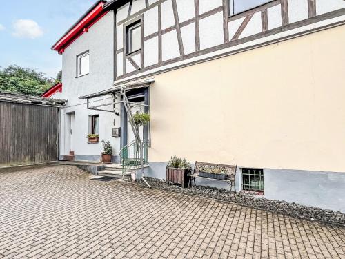 a white building with a bench next to it at Apartment Ferienwohnung Renata 1 nahe Nürburgring by Interhome in Quiddelbach