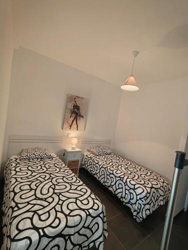 a bedroom with two beds and a picture on the wall at Bright in Agaete