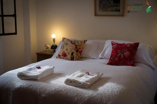 a white bed with towels on top of it at Posada La Diamela in La Cumbre