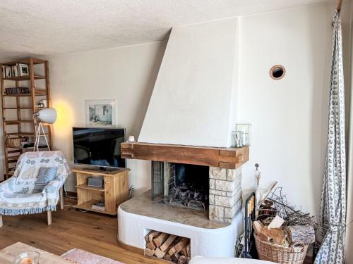 ein Wohnzimmer mit Kamin und Sessel in der Unterkunft Apartment Toissa A4 by Interhome in Salouf