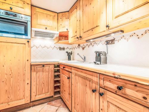 une cuisine avec des armoires en bois et un évier dans l'établissement Apartment Les Tommeuses - Val Claret-37 by Interhome, à Tignes