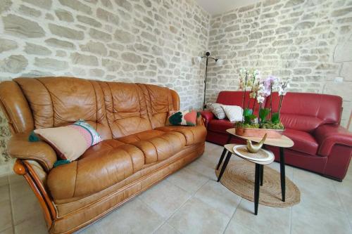 un salon avec un canapé en cuir marron et une table dans l'établissement Le paradis des pécheurs, à Châtillon-sur-Cher