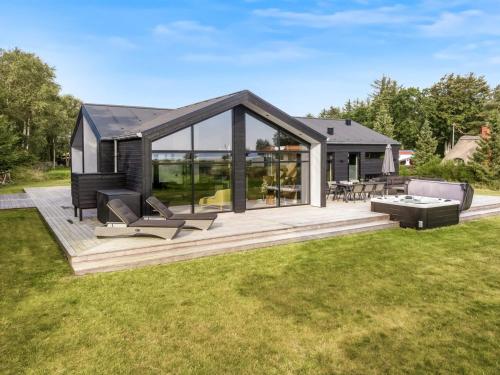 HøjslevにあるHoliday Home Jahn - 250m to the inlet by Interhomeの大きなデッキとガラスの壁を備えた現代的な家
