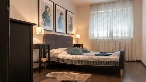 sypialnia z łóżkiem z obrazami na ścianie w obiekcie Thermal Forest Apartment w mieście Kiskunhalas