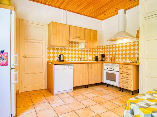 - une cuisine avec des placards en bois et des appareils blancs dans l'établissement Holiday Home Le Farigoulo by Interhome, à Sanary-sur-Mer