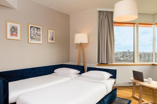 a hotel room with two beds and a window at Aparthotel Adagio Paris Centre Tour Eiffel in Paris