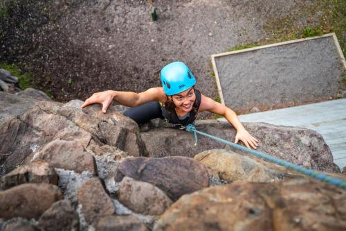 a woman in a blue helmet on some rocks at Delphi Resort Hotel & Spa in Leenaun