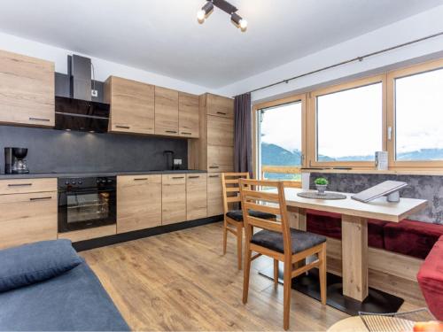 uma cozinha com armários de madeira e uma mesa e cadeiras em Apartment Gletscherblick by Interhome em Zell am See