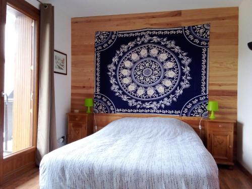 une chambre avec un lit avec une couverture bleue et blanche dans l'établissement Appartement des cimes du Granier, à Les Déserts