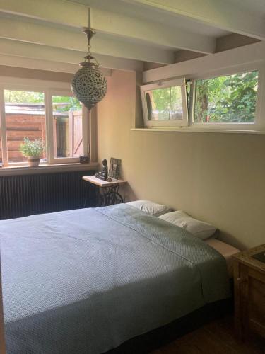 Un dormitorio con una cama y dos ventanas en Het Zalige Buitenleven, en Lanaken