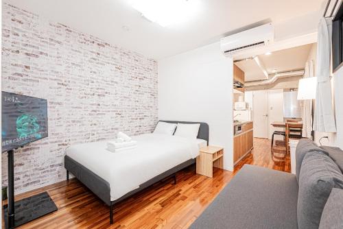 a bedroom with a bed and a brick wall at 67 Apt Nishishinjuku Premium in Tokyo