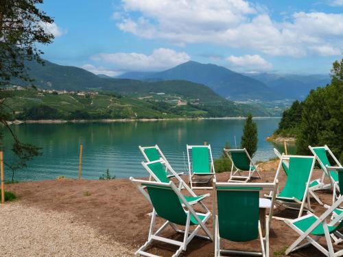 a row of chairs sitting next to a lake at Apartment Ermeti by Interhome in Sfruz