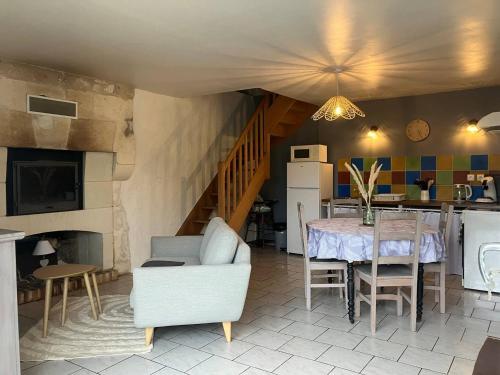 Il comprend un salon avec une table et une cuisine avec un escalier. dans l'établissement Charmante maison atypique, à Les Ulmes