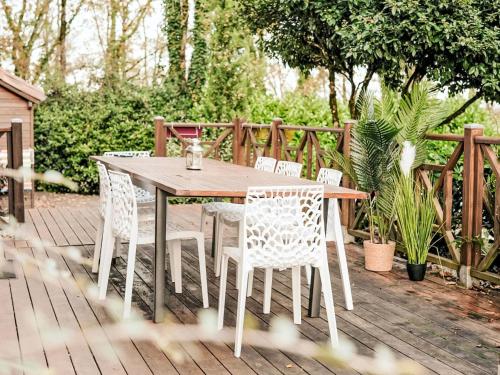 une table et des chaises en bois sur une terrasse en bois dans l'établissement Holiday Home L'Eglantier by Interhome, à Loupiac