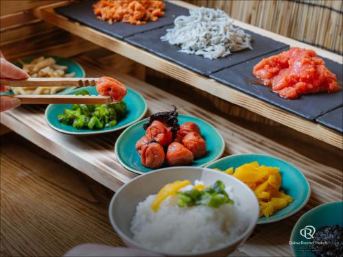 a table topped with plates of food and chopsticks at Daiwa Roynet Hotel Matsuyama in Matsuyama