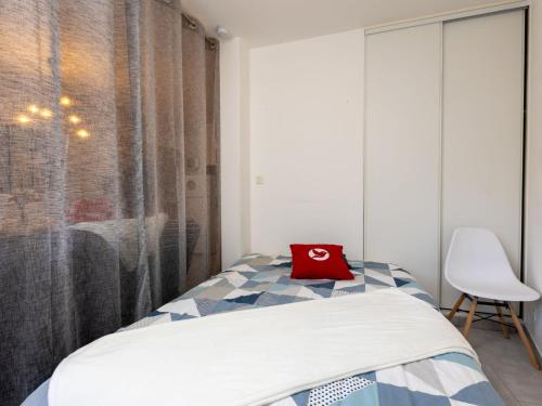 une chambre avec un lit avec un oreiller rouge dessus dans l'établissement Studio Nautica-2 by Interhome, à Saint-Malo