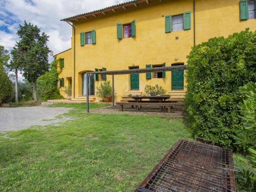 a yellow house with a picnic table in front of it at Holiday Home Mattonai by Interhome in Palaia