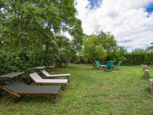 a group of picnic tables and chairs in the grass at Holiday Home Mattonai by Interhome in Palaia