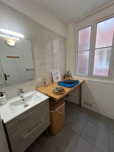 a bathroom with a sink and a mirror at Appartement Cosy et agréable in Colombes