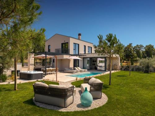 a house with a yard with chairs and a pool at Holiday Home Casa Tia 1 by Interhome in Nova Vas