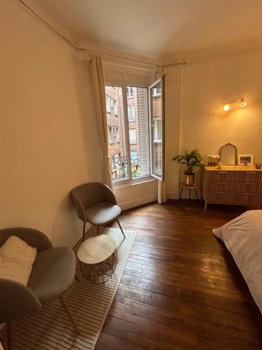 a living room with a bed and a window at Appartement Cosy et agréable in Colombes