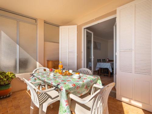 une salle à manger avec une table et des chaises blanches dans l'établissement Apartment Résidence Les Flots by Interhome, à Sanary-sur-Mer