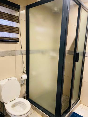 a bathroom with a toilet and a glass shower stall at President Guest Lodge in Louis Trichardt