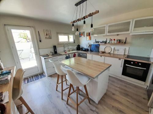 une cuisine avec une table en bois et des armoires blanches dans l'établissement Holiday Home La Roue à Aubes by Interhome, à LʼIsle-sur-la-Sorgue
