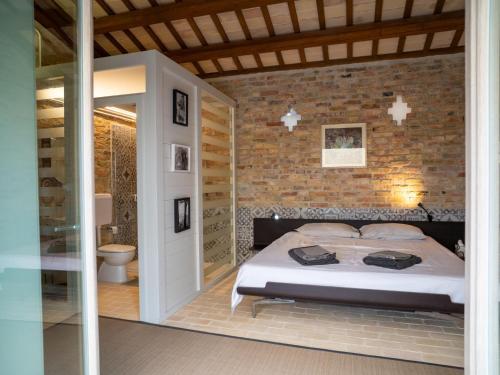a bedroom with a bed and a brick wall at Villa Mike's Dinghy House by Interhome in Citta' Sant'Angelo