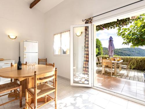 une cuisine et une salle à manger avec une table et une porte coulissante en verre. dans l'établissement Holiday Home Casa Murticcio 2 by Interhome, à Bonifacio