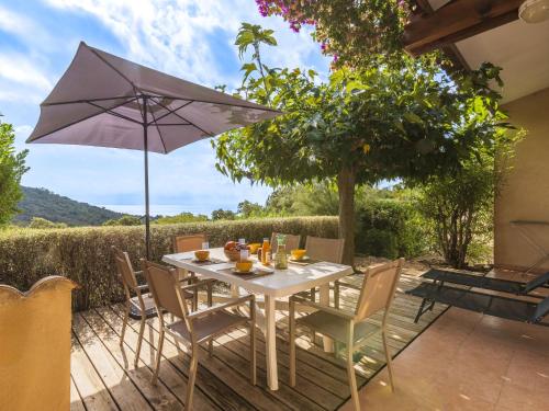 une table et des chaises avec un parasol sur une terrasse dans l'établissement Holiday Home Casa Murticcio 2 by Interhome, à Bonifacio