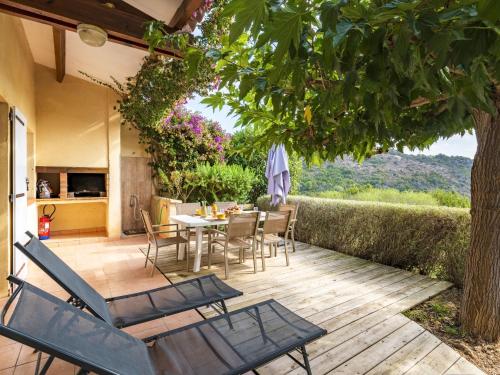 un patio avec une table et des chaises sous un arbre dans l'établissement Holiday Home Casa Murticcio 2 by Interhome, à Bonifacio