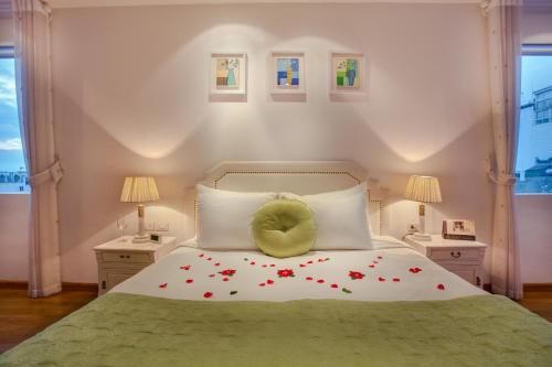 a bedroom with a bed with a yellow pillow on it at Mercury Central Hotel Hanoi in Hanoi