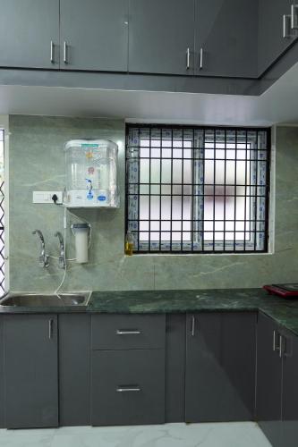 a kitchen counter with a sink and a window at Hill View Paradise - A luxurious 2bhk's & Private Rooms Near Bhudevi Complex TTD Ticket Counter Alipiri in Tirupati