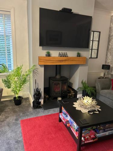 a living room with a fireplace and a flat screen tv at The Russell in Scarborough