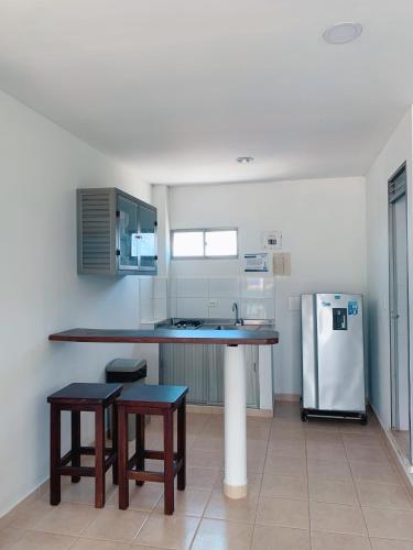 a kitchen with a counter and a refrigerator at Blue Apartahotel in Coveñas