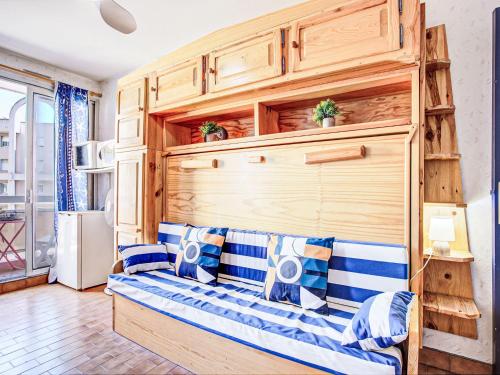 - un canapé dans une chambre dotée d'un mur en bois dans l'établissement Apartment Les Balcons de la Plage-6 by Interhome, à Canet