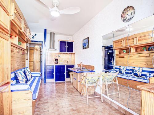 une cuisine avec des armoires bleues et une table et des chaises dans l'établissement Apartment Les Balcons de la Plage-6 by Interhome, à Canet