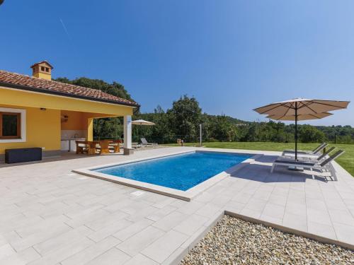 a villa with a swimming pool and an umbrella at Holiday Home Villa Ana Lucija by Interhome in Labin