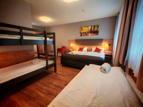 a bedroom with two bunk beds and a couch at Hotel La Mirabelle close to Europa Park in Rheinhausen