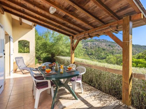 un patio avec une table et des chaises et une pergola en bois dans l'établissement Holiday Home Casa Murticcio 1 by Interhome, à Bonifacio