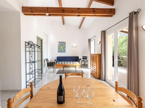 une salle à manger avec une table en bois et des verres à vin dans l'établissement Holiday Home Casa Murticcio 1 by Interhome, à Bonifacio