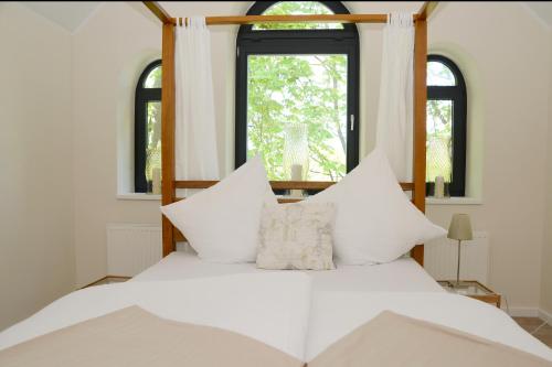 a bed with white pillows in a room with a window at Herberge der Alten Schule in Raddestorf