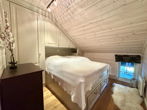 a bedroom with a white bed in a room at Cozy Ski-In Ski-Out Apartment on Geilo, Stunning Views! in Geilo
