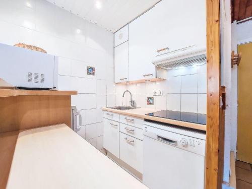 une cuisine blanche avec un évier et une cuisinière dans l'établissement Apartment Le Grand Tichot A et B - Val Claret-18 by Interhome, à Tignes