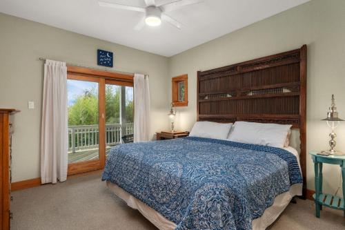 a bedroom with a large bed and a balcony at VOH151 FINALLY in Corolla