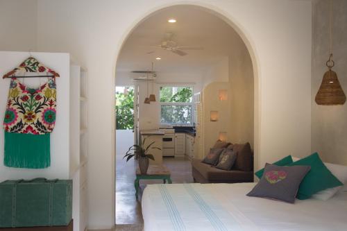 a bedroom with a bed and a living room at LiveTulum in Tulum