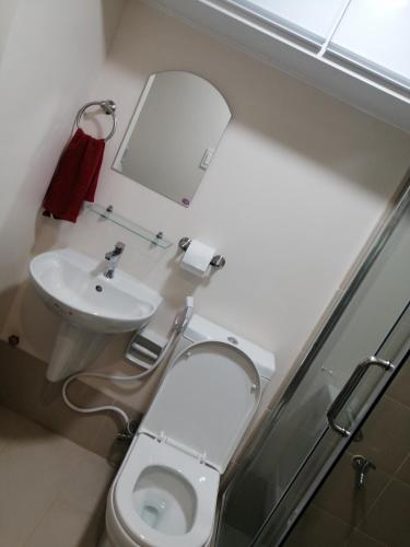 a bathroom with a toilet and a sink at Homey Staycation in Silang Cavite! Fullerton Suites Puting Kahoy - near CKS, AUP, PNPA, in Puting Kahoy