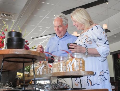 a man and woman standing next to a table with jars at Van der Valk Hotel Avifauna in Alphen aan den Rijn
