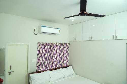 a bedroom with a bed and a ceiling fan at Hill View Paradise - A luxurious 2bhk's & Private Rooms Near Bhudevi Complex TTD Ticket Counter Alipiri in Tirupati
